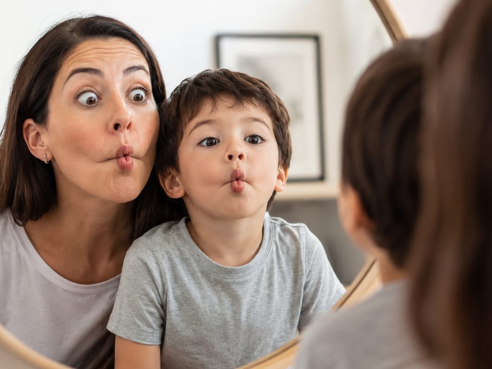 Mãe e filho fazendo caretas no espelho — Espelho das Emoções